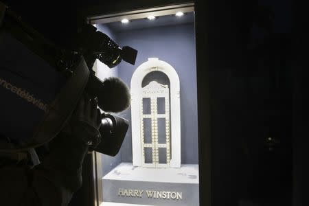 A television cameraman makes images of an empty display window at luxury jewellers Harry Winston after a robber stole diamonds worth 15 million euros ($16 million) in Cannes, France, January 18, 2017. REUTERS/Eric Gaillard