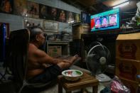 A man watches election results on television in his home in Bangkok on March 24, 2019 after polls closed in Thailand's general election