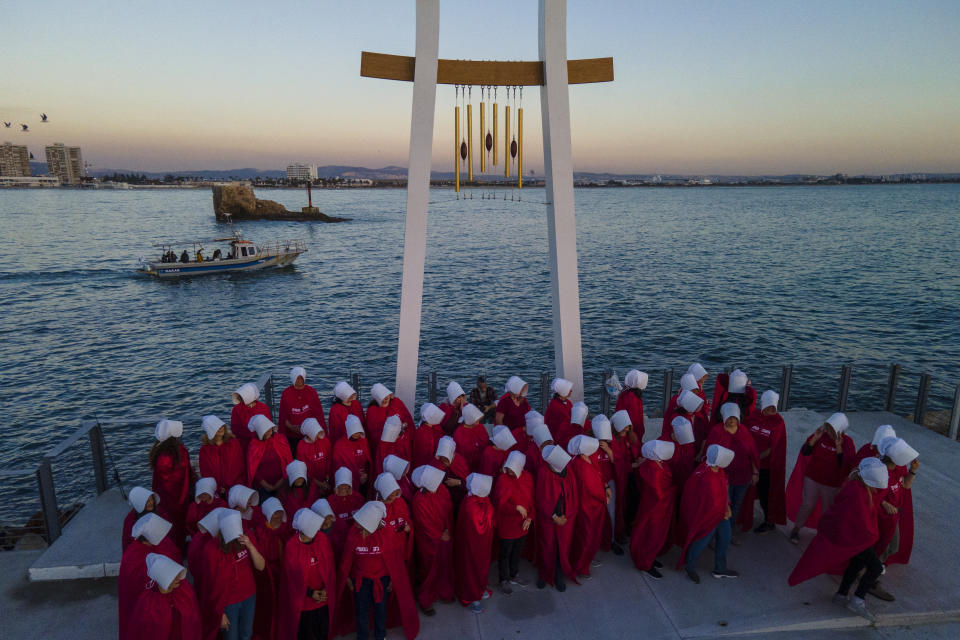 Protesters supporting women's rights dressed as characters from The Handmaid's Tale TV series attend a protest against plans by Prime Minister Benjamin Netanyahu's new government to overhaul the judicial system in the old port of Acre, north Israel, Thursday, March 16, 2023. (AP Photo/Ariel Schalit)