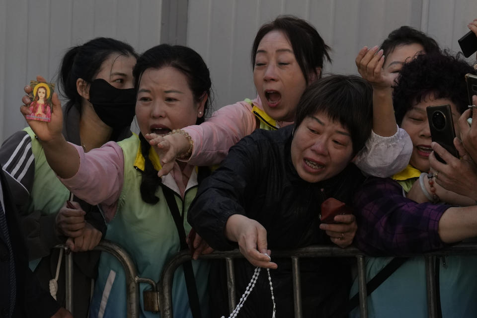 Faithful react as they see Pope Francis leaving in a car after a meeting with charity workers and the inauguration of the House of Mercy in Ulaanbaatar, Monday, Sept. 4, 2023. Francis toured the House of Mercy in the final event of an historic four-day visit to a region where the Holy See has long sought to make inroads. (AP Photo/Ng Han Guan)