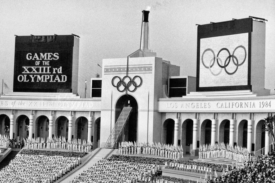 FILE - In this July 28, 1984, file photo, the Olympic flame is flanked by scoreboards signifying the formal opening of the Summer Olympic Games after it was lit by Rafer Johnson during the opening ceremonies in the Los Angeles Memorial Coliseum in Los Angeles. (AP Photo/Eric Risberg, File)