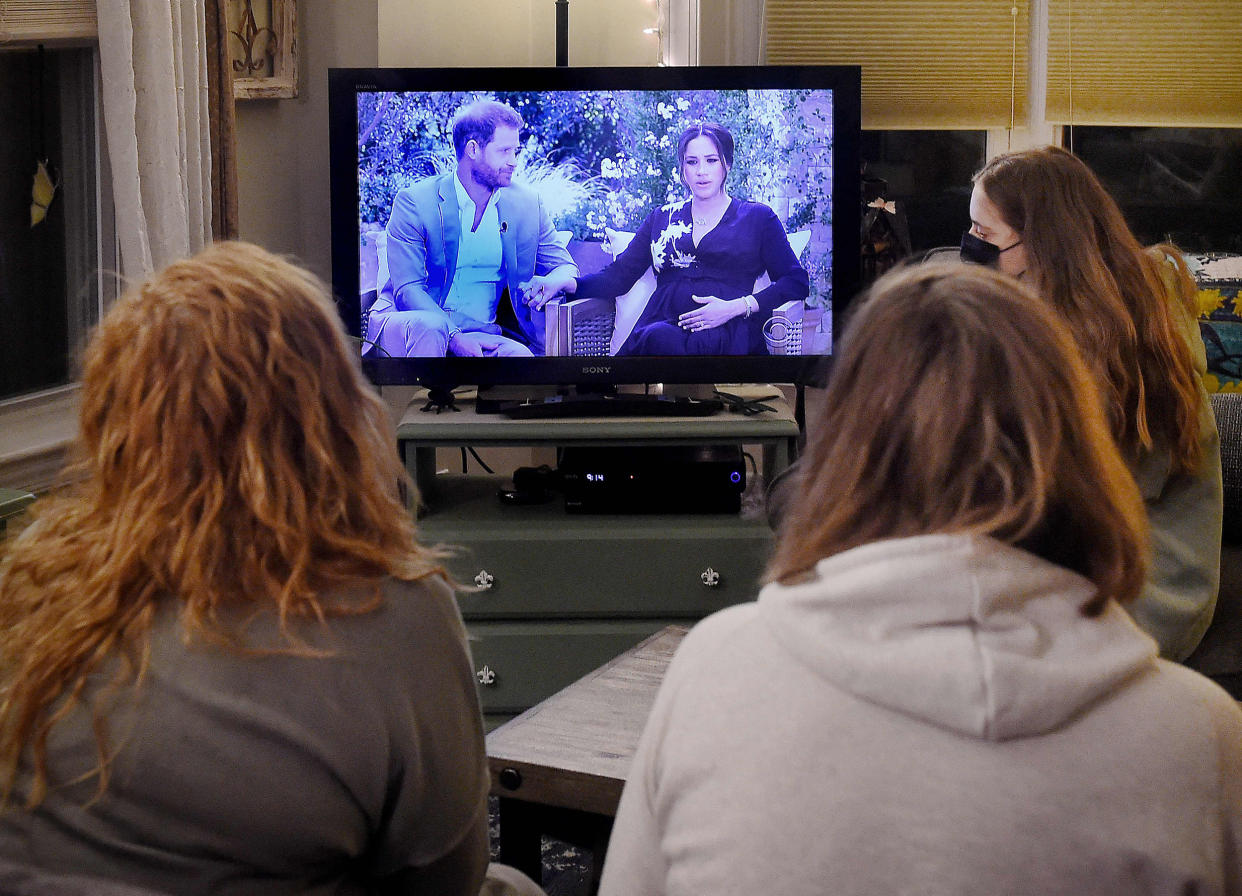 Image: People watch a televised conversation between Britain's Prince Harry with his wife Meghan Markle and Oprah Winfrey, in Arlington, Va., on March 7. (Olivier Douliery / AFP - Getty Images file)