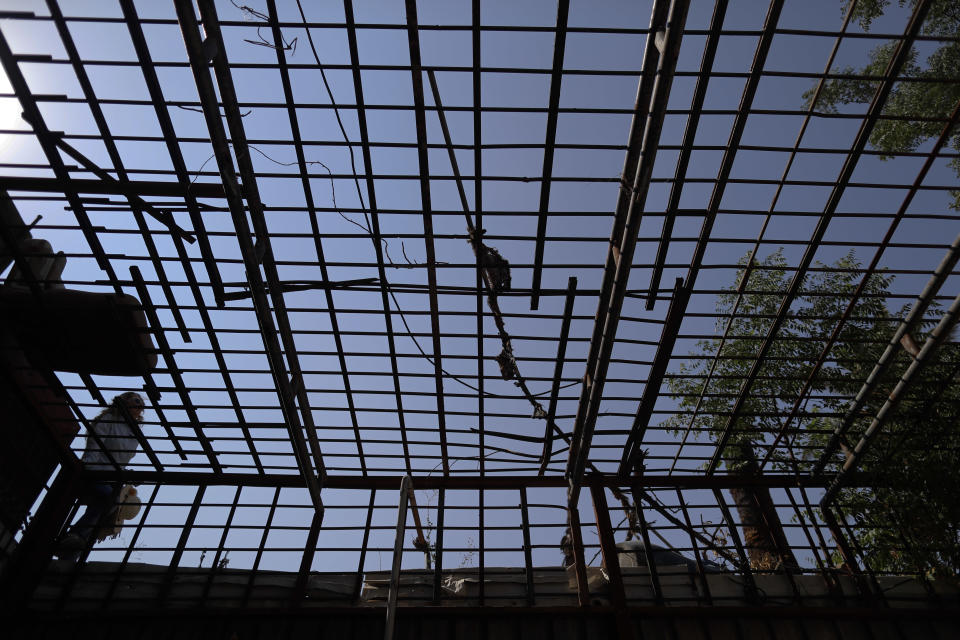 In this July 15, 2018 photo, a Syrian official walks next to a cage used by the Army of Islam for prisoners is abandoned Tawbeh Prison, in Douma, near the Syrian capital Damascus, Syria. The fate of activist Razan Zaitouneh is one of the longest-running mysteries of Syria’s civil war. There’s been no sign of life, no proof of death since gunmen abducted her and three of her colleagues from her offices in the rebel-held town of Douma in 2013. Now Douma is in government hands and clues have emerged that may bring answers. (AP Photo/Hassan Ammar)