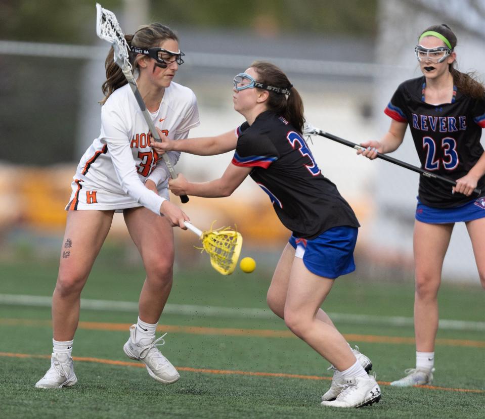 Hoover's Ava Streb scores a first period goal over defense from Revere's Mischa Mudrak and Taylor Catlett at Hoover, Thursday, April 27, 2023. 