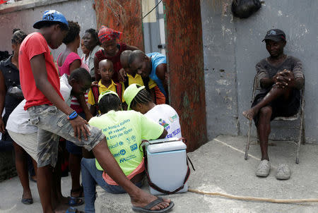 Residents speak to members of a vaccination campaign against cholera in a street of Les Cayes, Haiti, November 8, 2016. REUTERS/Andres Martinez Casares