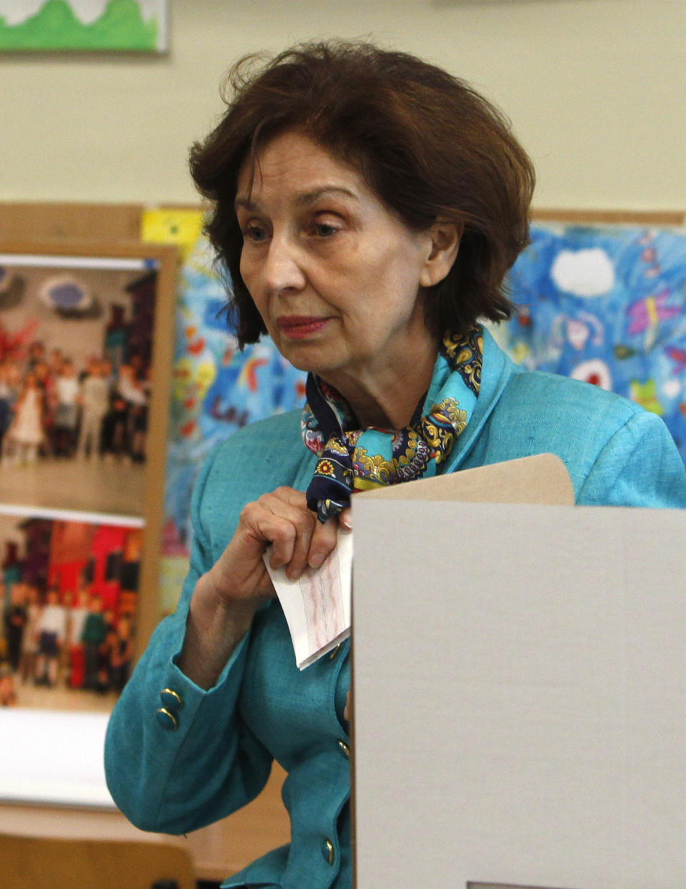 Gordana Siljanovska Davkova, a presidential candidate for the opposition conservative VMRO-DPMNE party, holds her ballot prior voting for the presidential elections at a polling station, in Skopje, North Macedonia, Sunday, April 21, 2019. North Macedonia holds the first round of presidential elections on Sunday, seen as key test of the government following deep polarization after the country changed its name to end a decades-old dispute with neighboring Greece over the use of the term "Macedonia". (AP Photo/Boris Grdanoski)