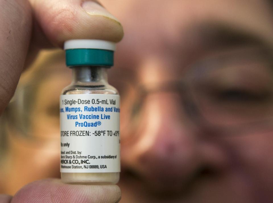 A pediatrician holds a dose of the measles-mumps-rubella (MMR) vaccine.