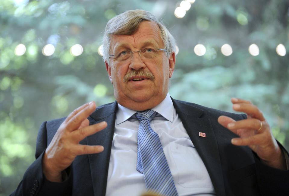 FILE - In this June 25, 2012 file photo, Walter Luebcke, who was in charge of the Kassel area regional administration, talks to media in Kassel, Germany. German investigators have carried out raids on dozens of people suspected of posting hate messages about the regional politician from Chancellor Angela Merkel’s party who was killed last year. Walter Luebcke, who led the regional administration in the central Kassel region, was shot on June 1, 2019. (Uwe Zucch/dpa via AP, file)