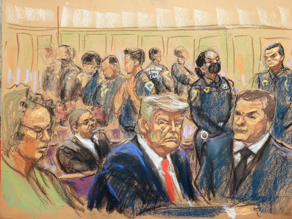 Former President Donald Trump sits at a table with counsel during an arraignment in New York City in a courtroom sketch. Police officers are seen in the background.