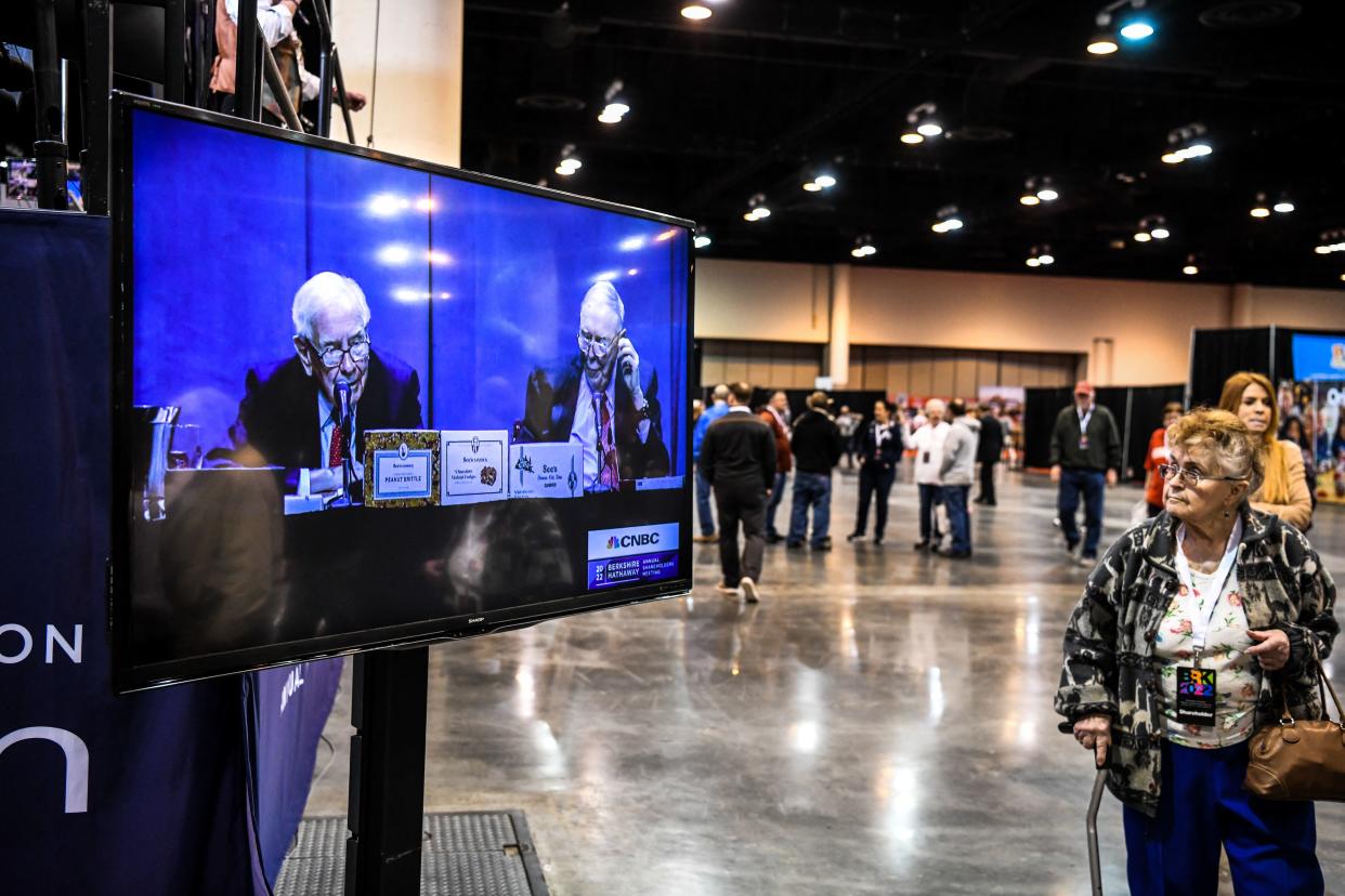 A woman looks at the screen with a live view of Berkshire Hathaway CEO Warren Buffett (L) and Vice Chairman Charlie Munger (R) at the Berkshire Hathaway Shareholders Meeting at CHI Health Center in Omaha, Nebraska on April 30, 2022. (Photo by CHANDAN KHANNA / AFP) (Photo by CHANDAN KHANNA/AFP via Getty Images)