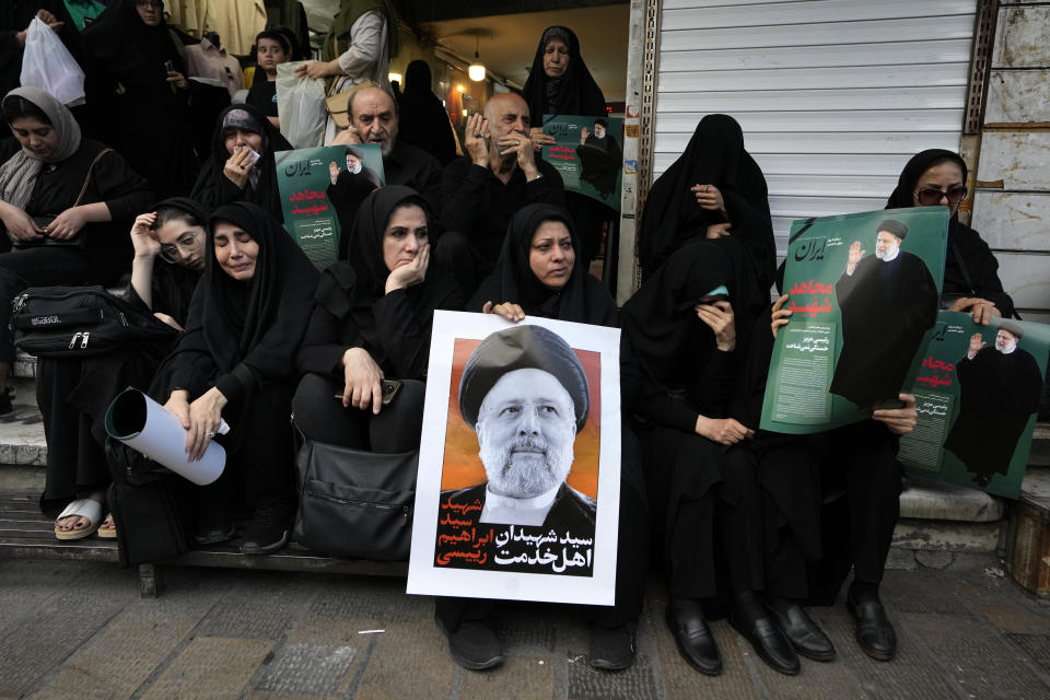 FILE - People hold up posters of Iranian President Ebrahim Raisi during a mourning ceremony for him at Vali-e-Asr square in downtown Tehran, Iran, Monday, May 20, 2024. The U.N. General Assembly’s tribute to Iran’s late President Raisi was snubbed by Western and East European nations on Thursday, May 30, amid protests against honoring a leader who was reviled for his crackdown on opponents. (AP Photo/Vahid Salemi, File)
