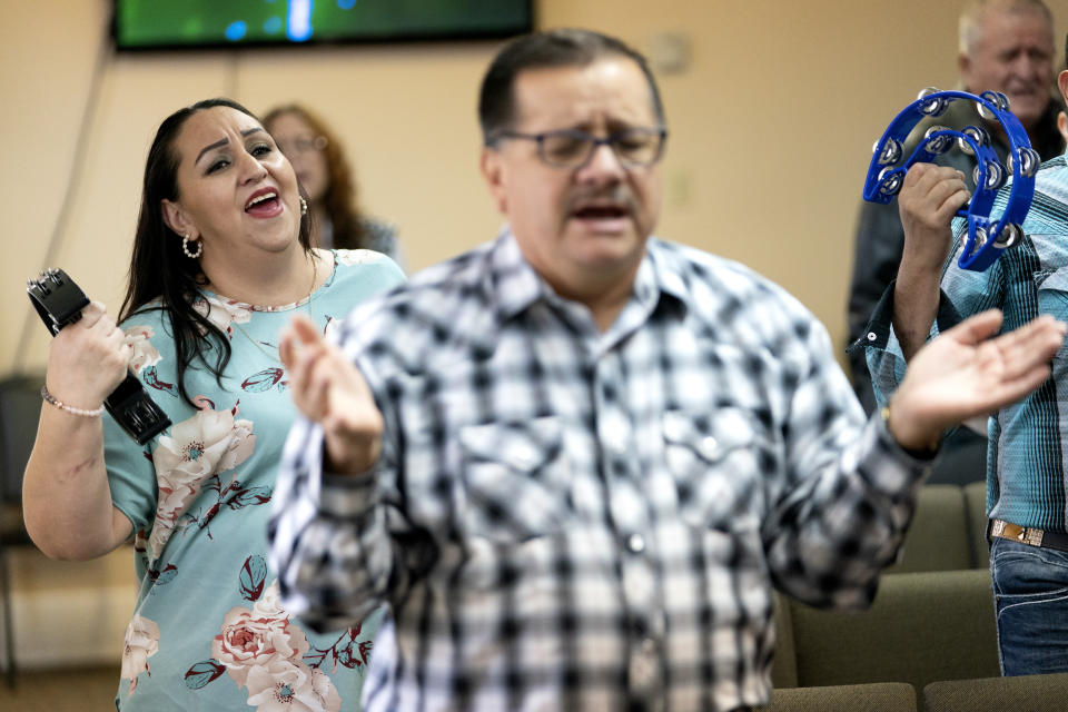 Guadalupe Rodriguez Pino, left, sings with members of her church's congregation as as they worship during a church service, Sunday, Dec. 17, 2023, in Fort Morgan, Colo. Rodriguez and her husband, who have four U.S.-born children, are in the process of getting legal immigration status. (AP Photo/Julio Cortez)