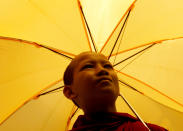 <p>Ein junger buddhistischer Mönch läuft mit seinem gelben Regenschirm durch die Straßen von Phnom Penh, der Hauptstadt von Kambodscha. (Bild: REUTERS/Samrang Pring) </p>