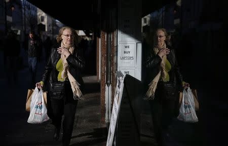 A pedestrian walks along King Street, the main shopping street in Kilmarnock, Scotland March 24, 2014. REUTERS/Suzanne Plunkett