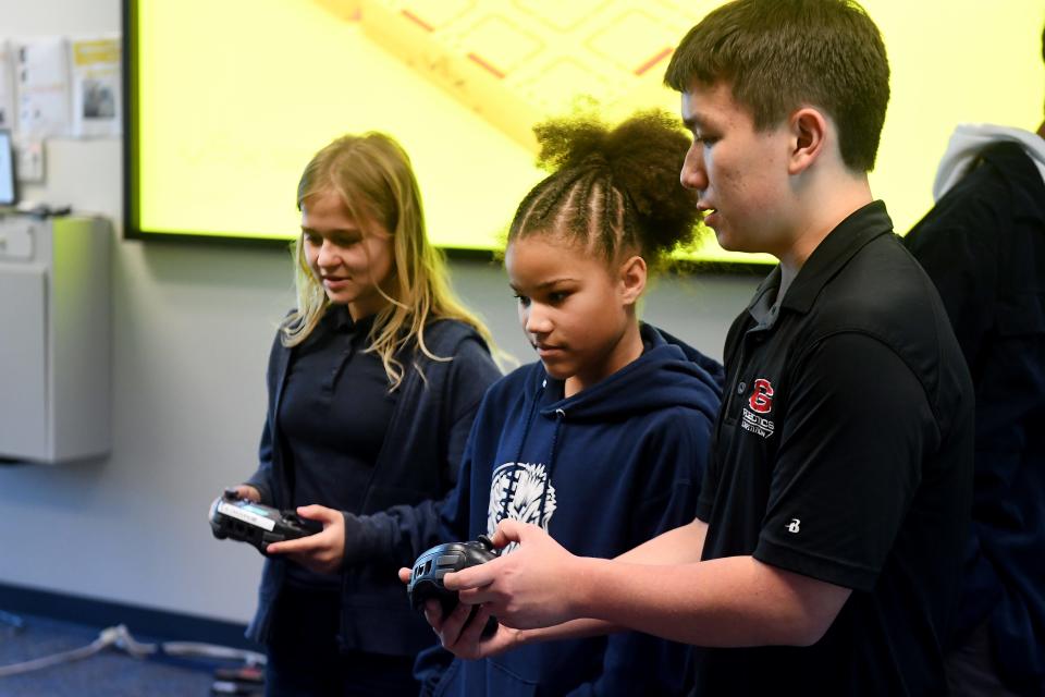 Christopher Koehler, right, a 10th grader at Grace Brethren School in Simi Valley, shows Samantha Walker and Olivia McCormick, of New Harvest Christian School in Oxnard how to control robots as part of a demonstration by the VEX Robotics Program at the Ventura County Science Fair on Friday, March 24, 2023.