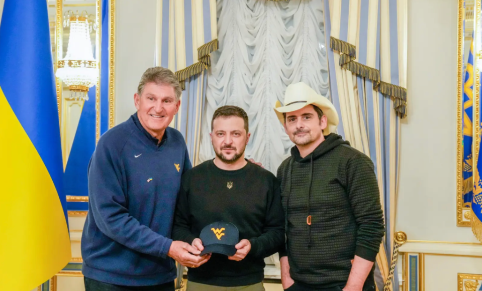 Sen. Joe Manchin, Ukrainian president Volodymyr Zelensky and country singer Brad Paisley as the leader accepts a University of West Virginia cap