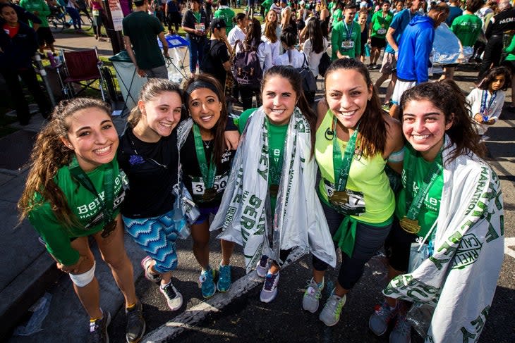 <span class="article__caption">Runners with their medals and thermo blankets smile for the camera at the finish line.</span>