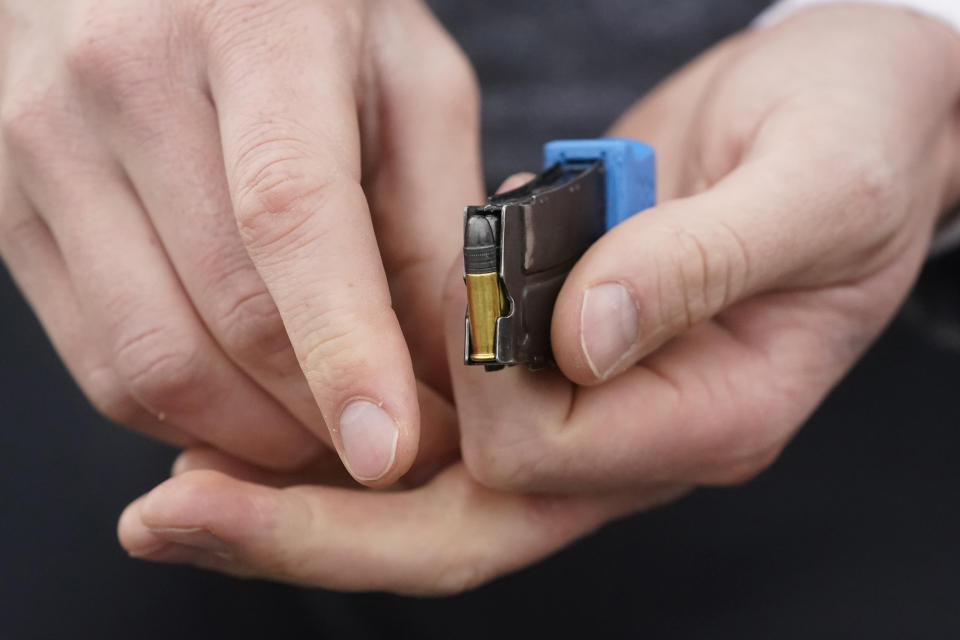 An athlete loads a bullet into a magazine during Biathlon World Cup Team Trials at Soldier Hollow on Oct. 24, 2021, in Midway, Utah. A biathlete skis several kilometers and arrives at the shooting range with a heart rate as high as 180 beats per minute. Next they shoot at five targets within 25 to 35 seconds. (AP Photo/Rick Bowmer)