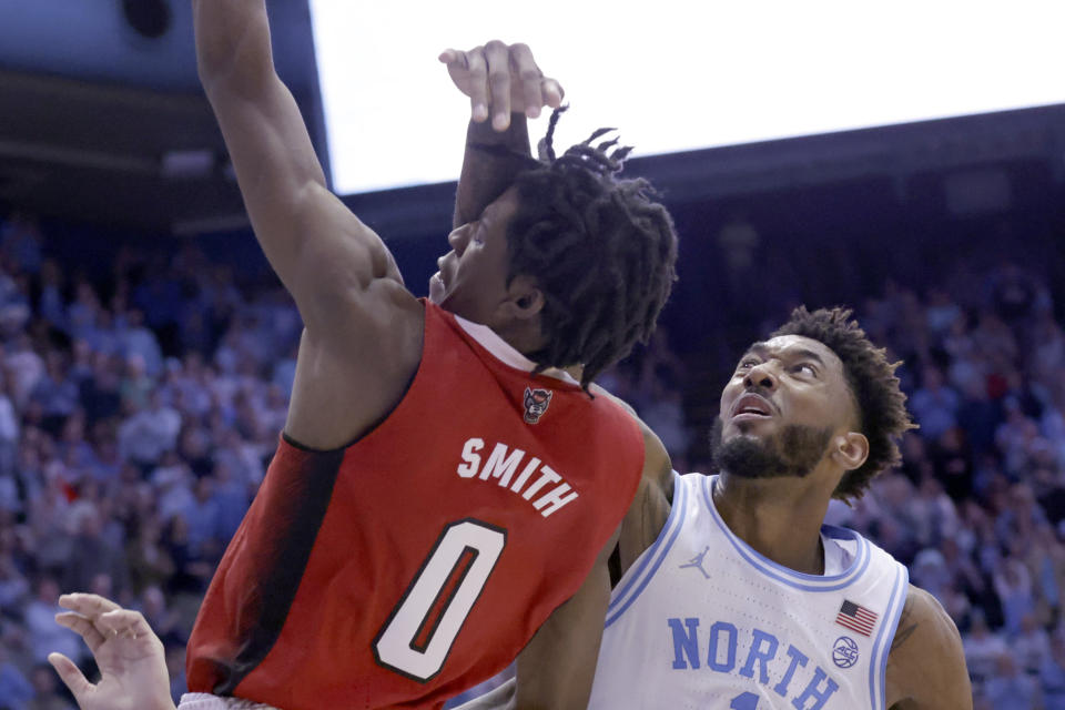 North Carolina State guard Terquavion Smith (0) is fouled by North Carolina forward Leaky Black, right, as he drives to the basket during the second half of an NCAA college basketball game Saturday, Jan. 21, 2023, in Chapel Hill, N.C. Smith crashed to the floor and was taken off the court. (AP Photo/Chris Seward)