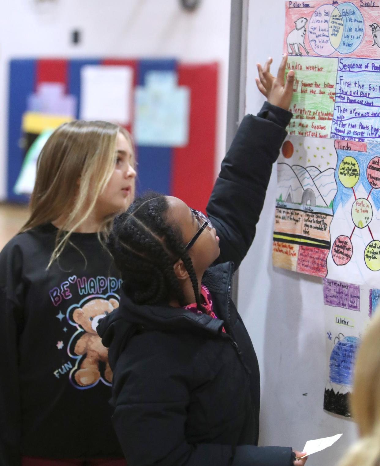 Madison Margiotta, left, and Omani Solomon show the project they worked on Jan. 9 at Cottage Lane Elementary in Blauvelt. Fourth-graders at the school worked on the projects as a cumulation of their Reading the Weather — Reading the World studies. Parents were invited in to view the group projects they made during publishing parties held in the school gymnasium.