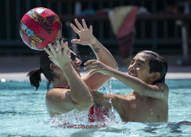 SANTA CLARITA, CA - JULY 07: Inez Esparza and her son Ezrah (cq) Esparza, 10, beat the triple-digit heat at Newhall Park Community Pool in Santa Clarita on Wednesday, July 7, 2021. The National Weather Service on Wednesday issued an excessive heat warning across portions of Southern California's high desert, with the Apple and Lucerne valleys preparing for temperatures that could climb as high as 120 degrees by the weekend - potentially the hottest of the year so far. (Myung J. Chun / Los Angeles Times)