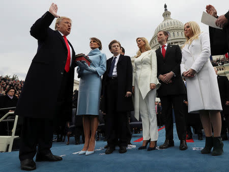 U.S. President Donald Trump takes the oath of office as his wife Melania holds the bible and his children Barron, Ivanka, Eric and Tiffany watch as U.S. Supreme Court Chief Justice John Roberts (R) administers the oath during inauguration ceremonies swearing in Trump as the 45th president of the United States on the West front of the U.S. Capitol in Washington, DC, U.S., January 20, 2017. REUTERS/Jim Bourg