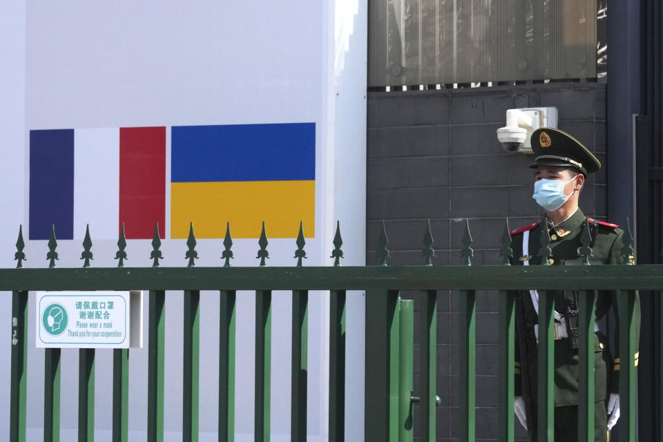 A paramilitary police officer guards the entrance to the French Embassy where the French and Ukrainian flags are shown side by side on Thursday, March 3, 2022, in Beijing. China on Thursday denounced a report that it asked Russia to delay invading Ukraine until after the Beijing Winter Olympics as "fake news" and a "very despicable" attempt to divert attention and shift blame over the conflict. (AP Photo/Ng Han Guan)