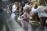 Relatives and friends visit the 9/11 Memorial during a ceremony marking the 12th anniversary of the attacks on the World Trade Center in New York September 11, 2013. (REUTERS/David Handschuh)