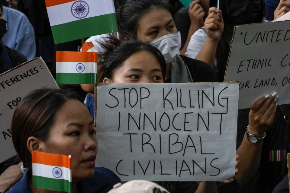 Members of the Kuki tribe protesting against the killing of tribals in their northeastern home state of Manipur, hold Indian flags and placards during a sit in protest in New Delhi, India, Monday, May 29, 2023. Manipur, which borders Myanmar, has been roiled by violence since 3 May after members of tribal groups clashed with a non-tribal group over demands of economic benefits and reservation status. More shootings and arson were reported Monday from the northeastern state, where dozens have been killed and more than 35,000 displaced following the worst ethnic clashes seen in decades. (AP Photo/Manish Swarup)