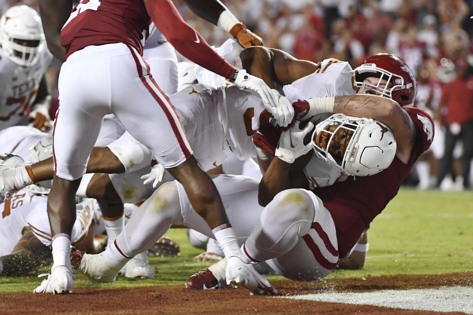 Texas running back Bijan Robinson (5) pushes past Arkansas defensive lineman John Ridgeway (99) to score a touchdown in the second half of an NCAA college football game Saturday, Sept. 11, 2021, in Fayetteville, Ark. (AP Photo/Michael Woods)