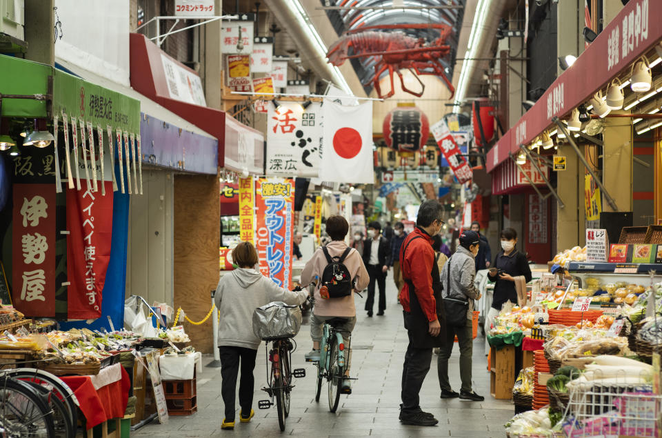 People wearing face masks to help curb the spread of the coronavirus shop around at the Kuromon Ichiba market in Osaka, western Japan, Tuesday, April 20, 2021. (AP Photo/Hiro Komae)