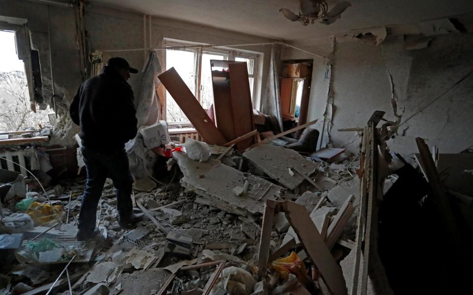 A local resident walks inside a damaged apartment in the besieged city of Mariupol - Alexander Ermochenko/Reuters