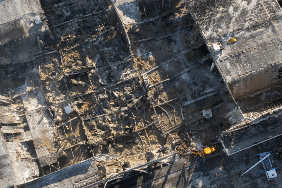 Ukrainian State Emergency Service firefighters work to take away debris at a shopping center burned after a rocket attack in Kremenchuk, Ukraine, Tuesday, June 28, 2022. (AP Photo/Efrem Lukatsky)