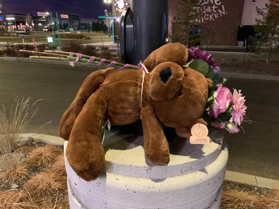 A teddy bear and flowers left at the scene of Thursday's shooting of a father and his 11-year-old boy.