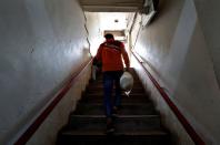 A gig worker carries groceries he picked up for an order from a Swiggy's grocery warehouse, in New Delhi