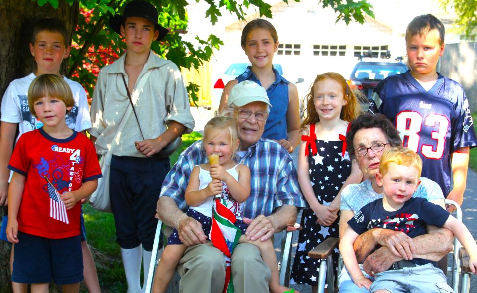 Merrill and Polly Leavens in Squantum in 2013 on the Fourth of July. Back row: Noah, Nathan and Grace Campbell, and Wes Jones. Middle row: Guthrie Gatewood, Merrill with Adeline Gatewood on his lap, Posey Polly Jones, Polly with Tobey Heinrichsen on her lap.