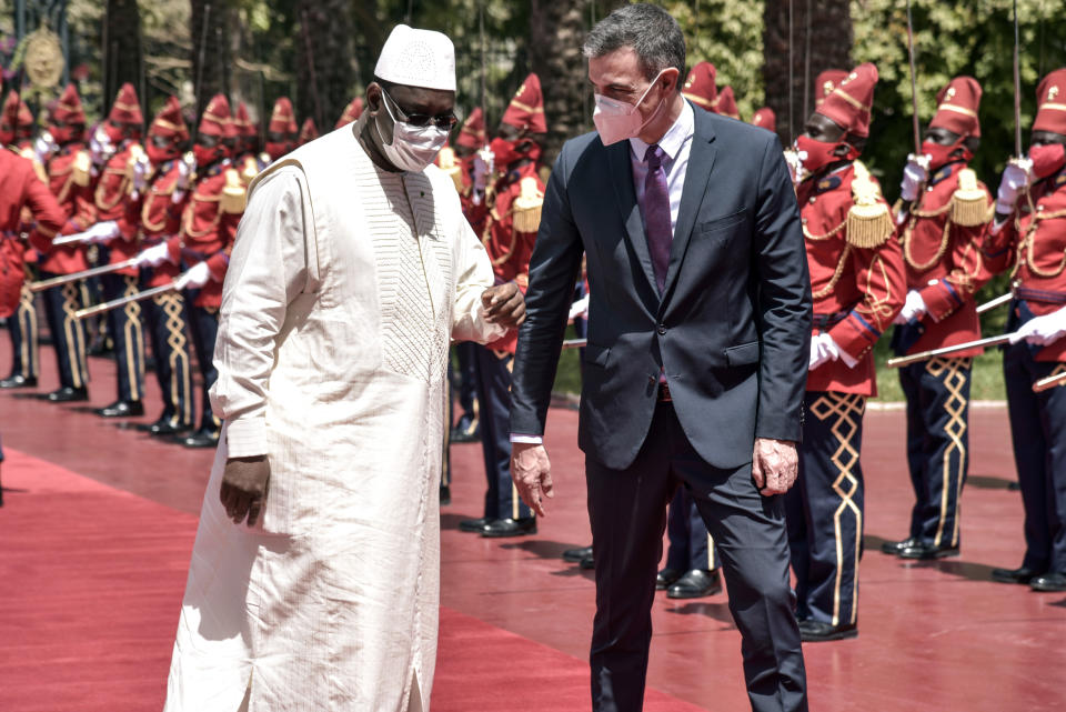 Spanish Prime Minister Pedro Sanchez, right, is received by Senegalese President Macky Sall at the Palace of the Republic in Dakar, Senegal, Friday, April 9 2021 after his meeting with Senegalese President Macky Sall. Sanchez is on a mini-tour to two African nations that are key in the European country's new push to bolster ties with the neighboring continent and mitigate the migration flows that many fear could increase as a consequence of the coronavirus pandemic.(Seyllou/Pool Photo via AP)