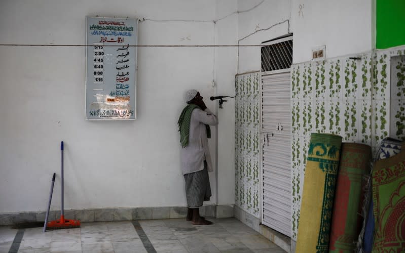 A muezzin makes his call to afternoon prayers inside a mosque in Ayodhya