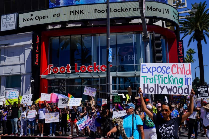 HOLLYWOOD, CA - JULY 31: Protesters stand along Hollywood boulevard near the Hollywood and Highland center on Friday, July 31, 2020 in Hollywood, CA. Conspiracy theorists held the first "Child Lives Matter" protest in Hollywood to "expose" child trafficking, advertising the event with references to adrenochrome - a favorite topic of interconnected QAnon and Pizzagate conspiracy communities; and despite the so-called "adrenochrome harvesting" long predating these groups it has re-emerged during the Coronavirus pandemic. (Kent Nishimura / Los Angeles Times)