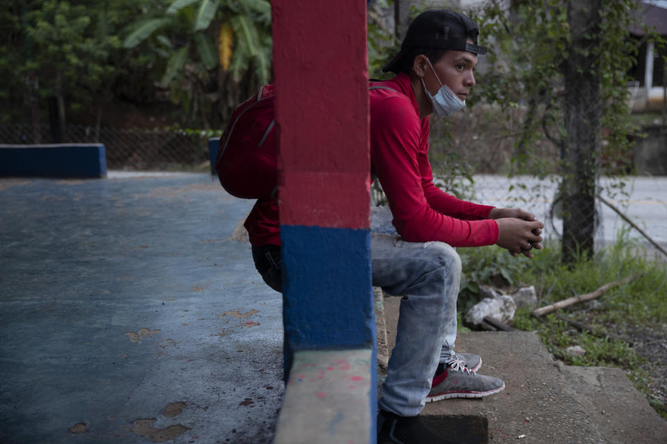 Honduras migrant Hector Eduardo Ramirez, 20, rests in San Luis Peten, Guatemala, Saturday, Oct. 3, 2020. Early Saturday, hundreds of migrants who had entered Guatemala this week without registering were being bused back to their country's border by authorities after running into a large roadblock. (AP Photo/Moises Castillo)
