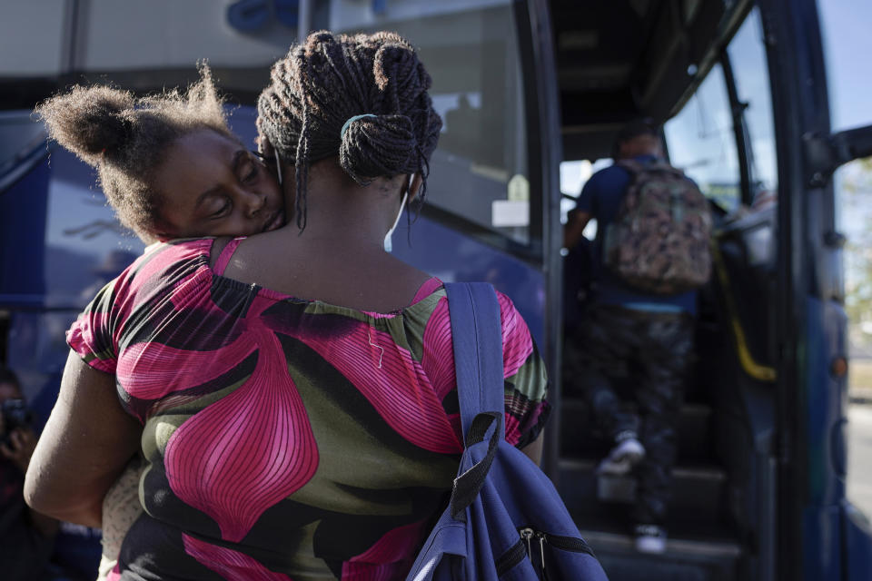 FILE - A child sleeps on the shoulder of a woman as they prepare to board a bus to San Antonio moments after a group of migrants, many from Haiti, were released from custody upon crossing the U.S.-Mexico border in search of asylum in Del Rio, Texas on Sept. 22, 2021. Biden and senior officials talked tough — "Do not come," Vice President Kamala Harris warned on a June visit to Guatemala, repeating herself for emphasis — but migrants who kept coming spoke of the change in presidential administrations and stories from friends and relatives who were quickly released in the United States. (AP Photo/Julio Cortez, File)
