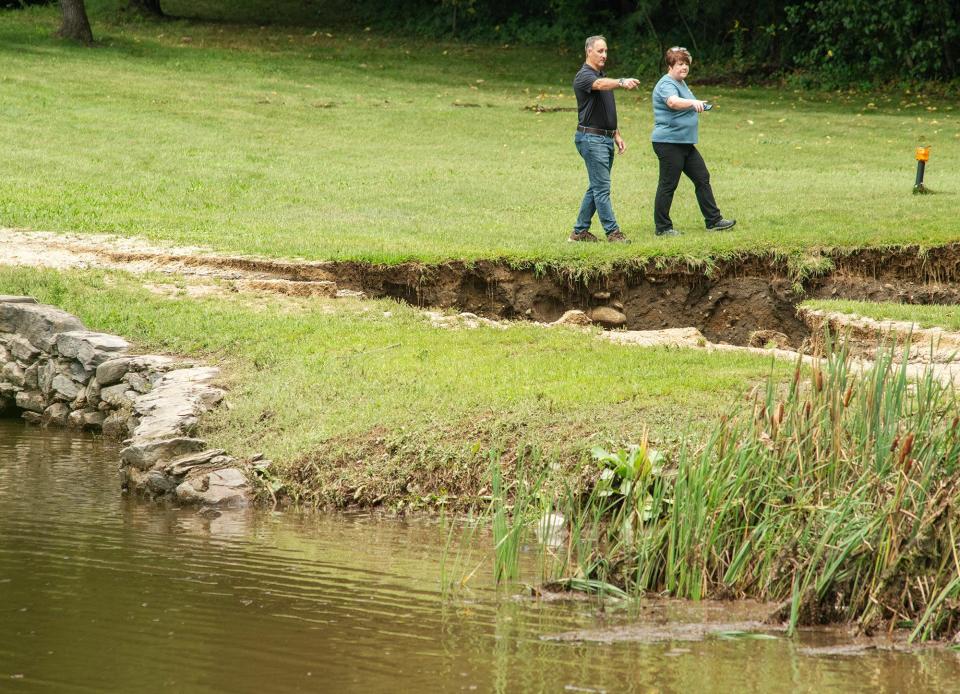 LEOMINSTER - Leominster Parks & Recreation Department officials inspect damage to the earthen dam at the edge of Colburns Reservoir in Barrett Park a day after flash floods hit the area Tuesday September 12, 2023.