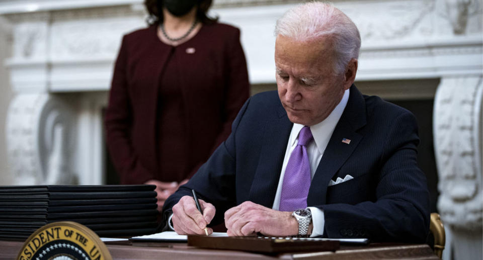 Joe Biden signs executive orders in the Oval Office on his first day of president. 