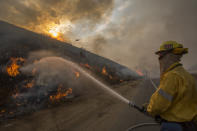 <p>Firefighters use hoses and helicopters to fight the La Tuna fire on Sept. 2, 2017 near Burbank, Calif. (Photo: David McNew/Getty Images) </p>