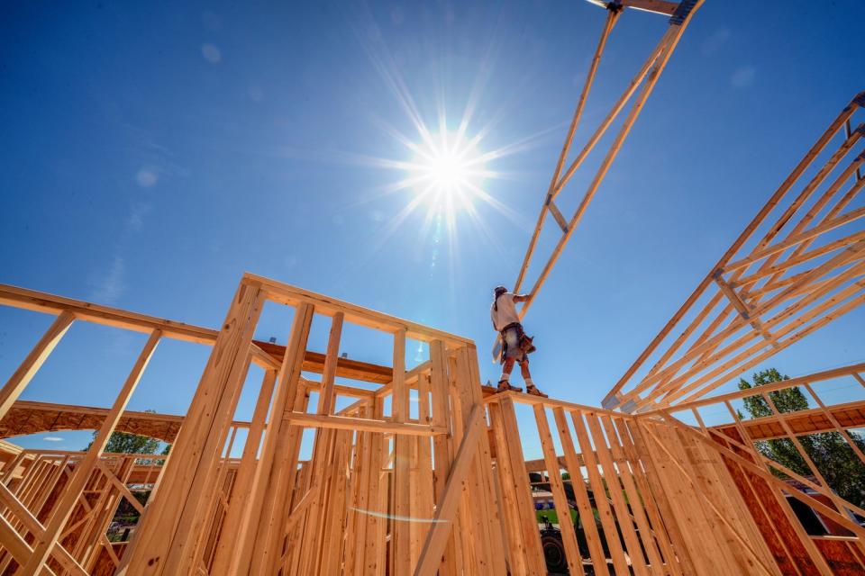 A person building a home with the sun shining brightly.