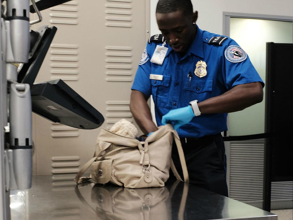 A Transportation Security Administration (TSA) worker screens passengers: Spencer Platt/Getty Images