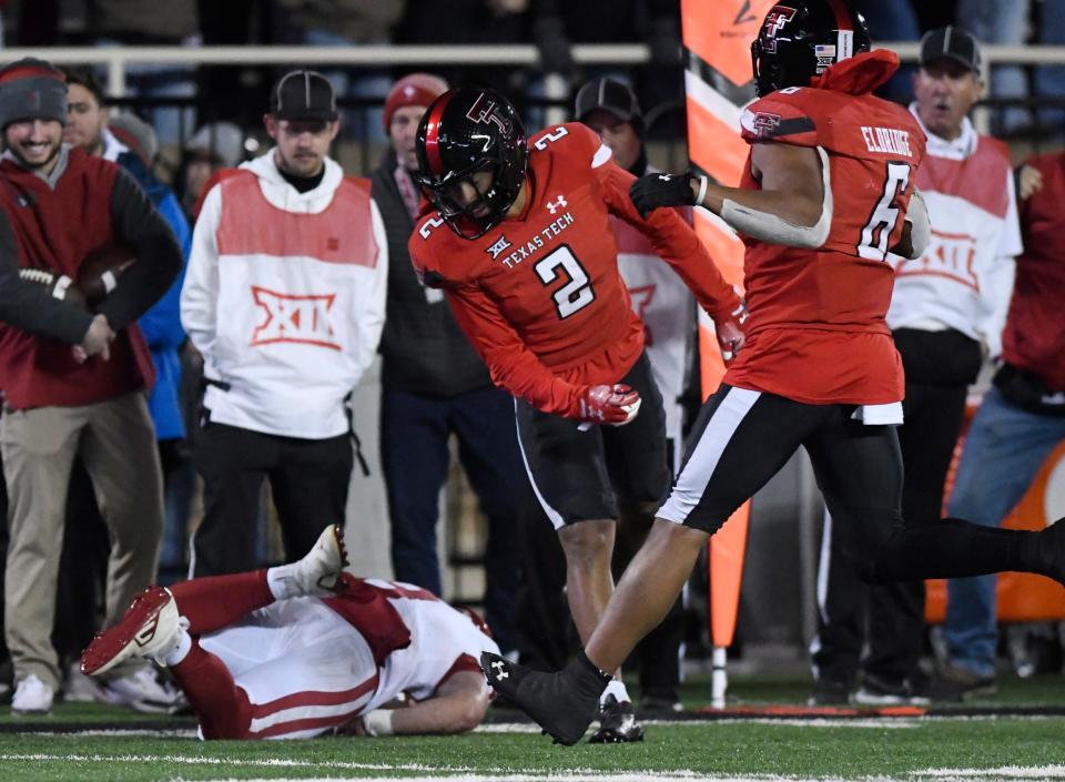 Texas Tech's defensive back Reggie Pearson Jr. (2), center, tackles Oklahoma's quarterback Dillon Gabriel (8), Saturday, Nov. 26, 2022, Jones AT&T Stadium. 