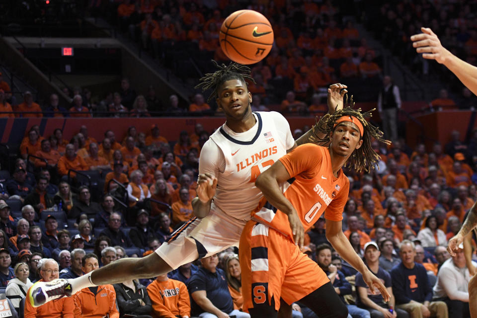 Illinois' Dain Dainja (42) and Syracuse's Chris Bell vie for a rebound during the first half of an NCAA college basketball game Tuesday, Nov. 29, 2022, in Champaign, Ill. (AP Photo/Michael Allio)