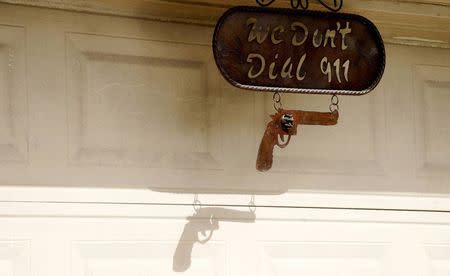 A sign reading "We don't dial 911" hangs outside Fernando Rivera Jr.'s house in Brownsville, Texas September 2, 2014. REUTERS/Rick Wilking