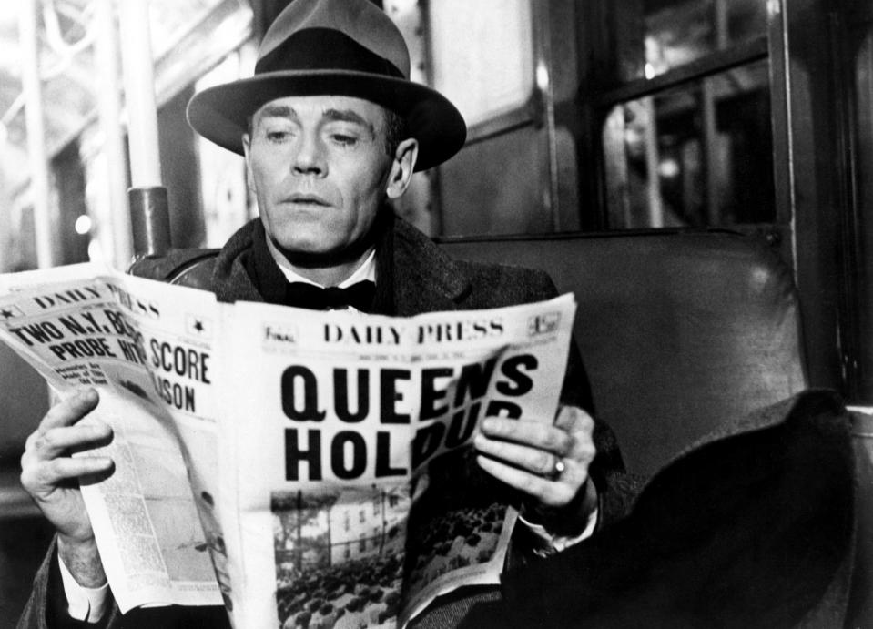Henry Fonda reading a newspaper.